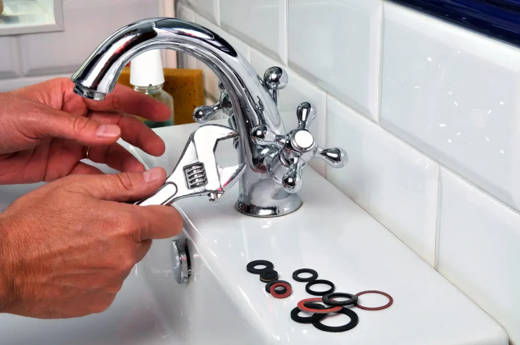 Plumber performing maintenance on a bathroom faucet in West Jordan