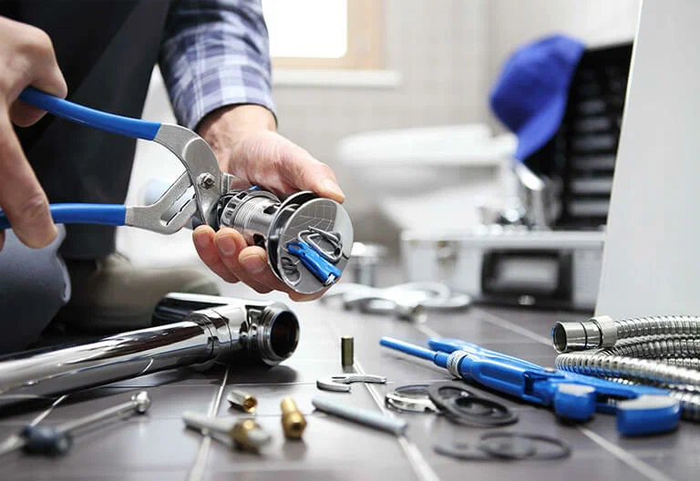 Technician repairing a plumbing fixture with professional tools in West Jordan