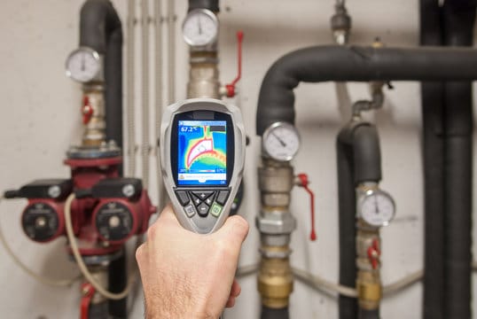 Plumber using a thermal imaging camera to inspect pipes in West Jordan