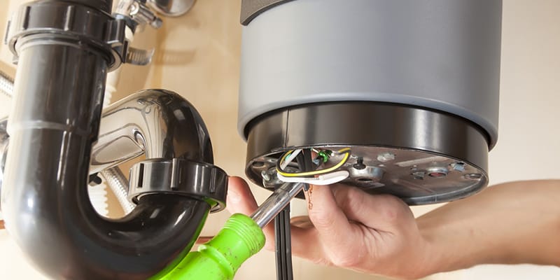 Technician repairing the heating element of a water heater in West Jordan