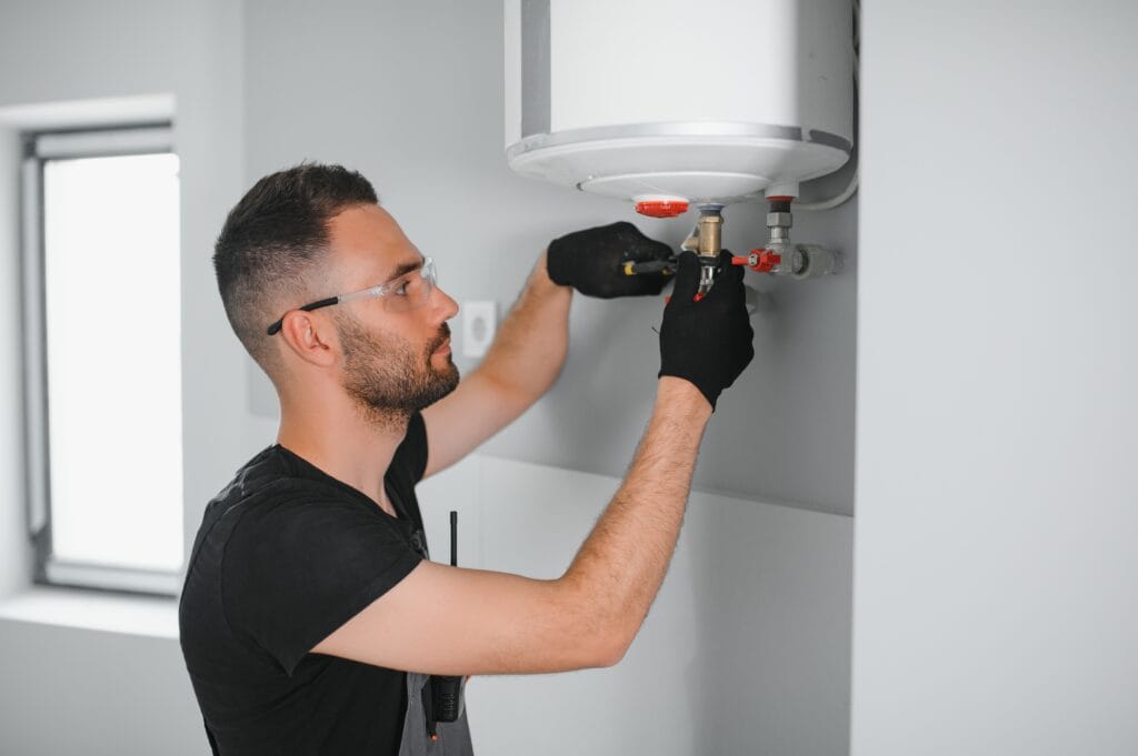 Technician performing water heater maintenance in West Jordan
