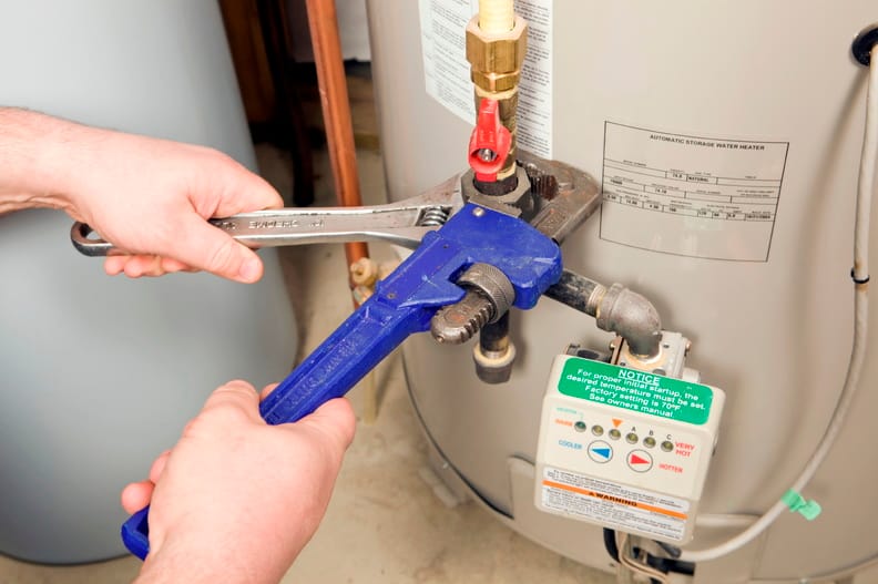 Plumber repairing a water heater valve in West Jordan